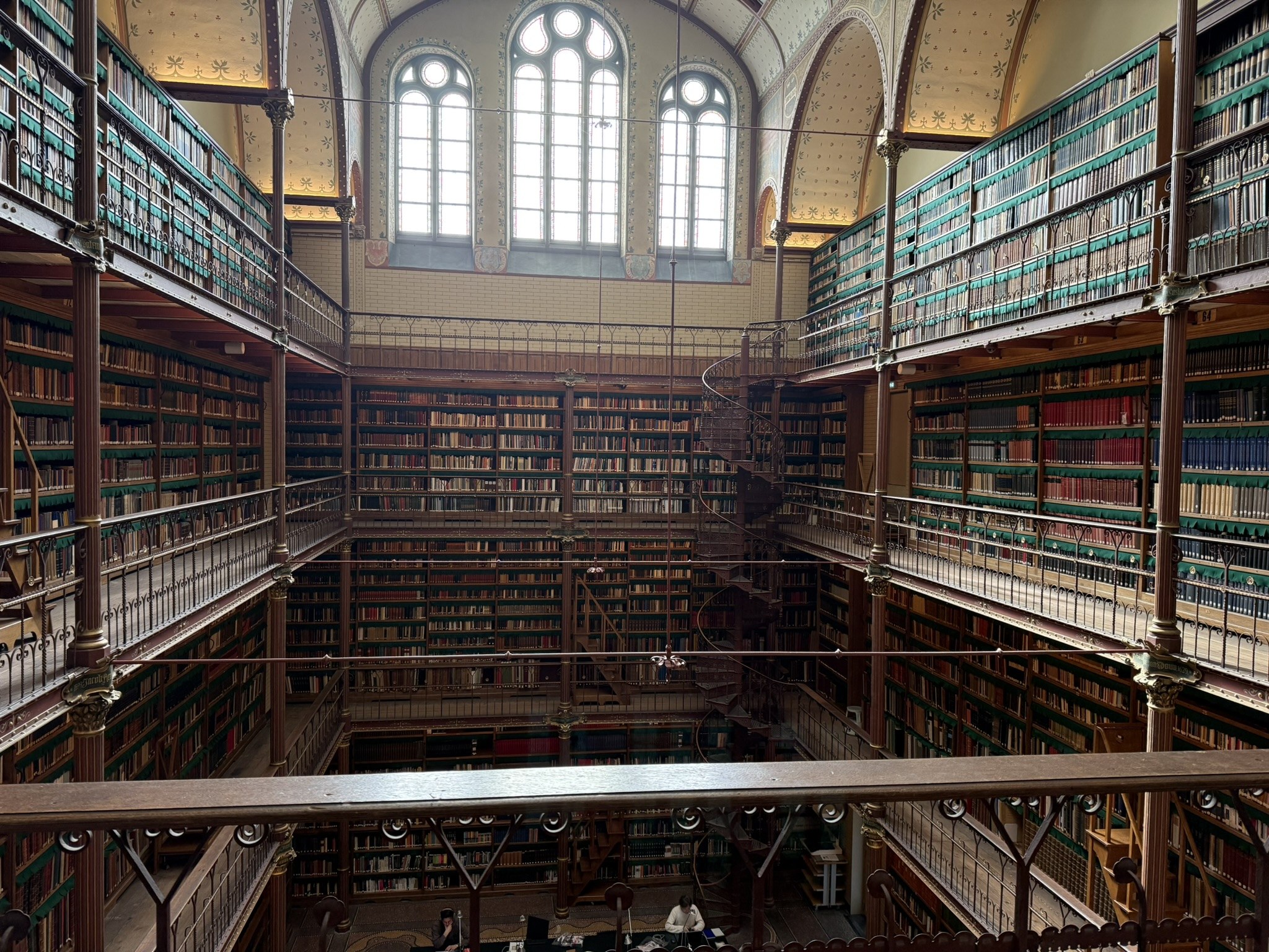 Bookshelves and arched windows in a historic library.